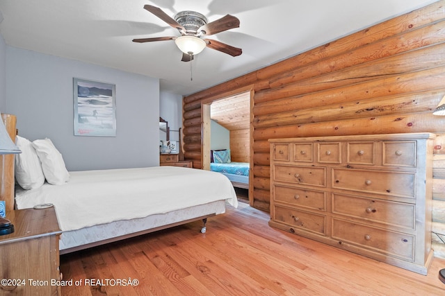 bedroom featuring rustic walls, a ceiling fan, and light wood-style floors