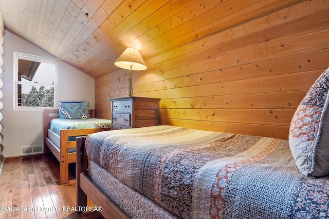 bedroom with wooden ceiling, visible vents, vaulted ceiling, and hardwood / wood-style flooring