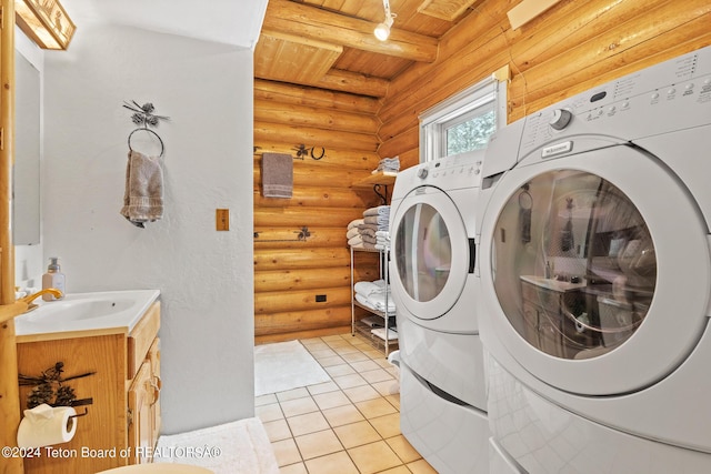 washroom featuring log walls, washer and clothes dryer, light tile patterned flooring, a sink, and wooden ceiling