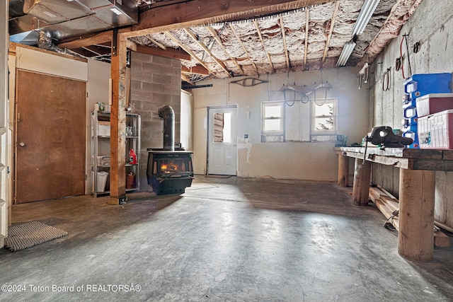 interior space with a wood stove, concrete floors, and a workshop area