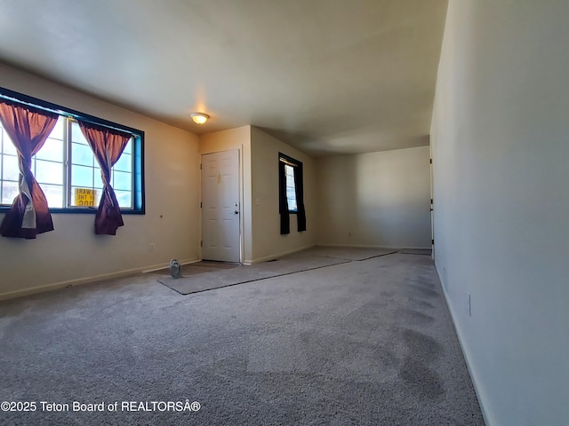 carpeted spare room featuring baseboards