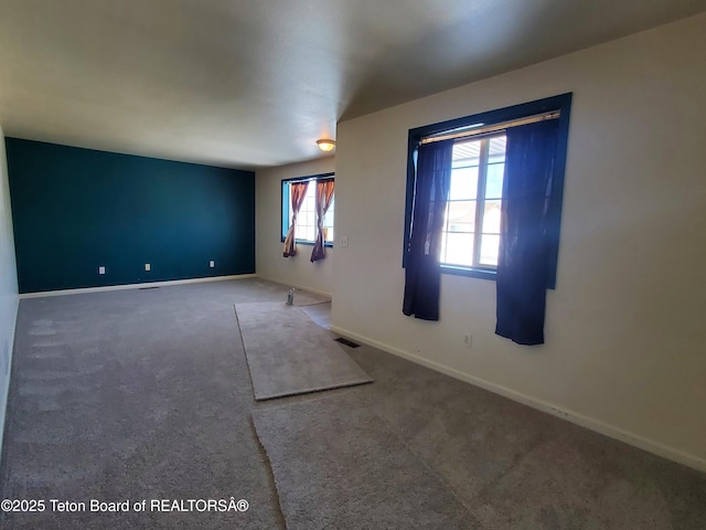 spare room with baseboards and visible vents