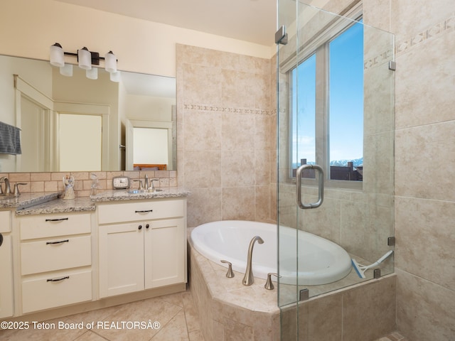 70 Baywood Dr, Driggs, ID 83422 - bathroom with a relaxing tiled tub, a stall shower, tile patterned flooring, and double vanity