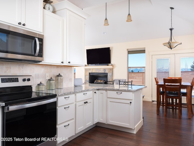 70 Baywood Dr, Driggs, ID 83422 - kitchen with lofted ceiling, stainless steel appliances, a peninsula, white cabinetry, and tasteful backsplash