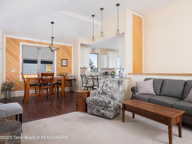 living room featuring lofted ceiling, carpet flooring, and wood walls