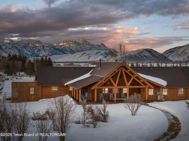 view of front of home featuring metal roof, log exterior, and a mountain view