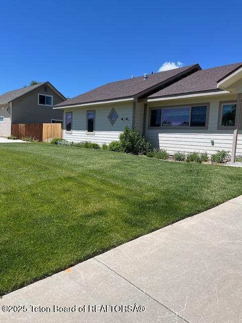 view of front of home with fence and a front yard