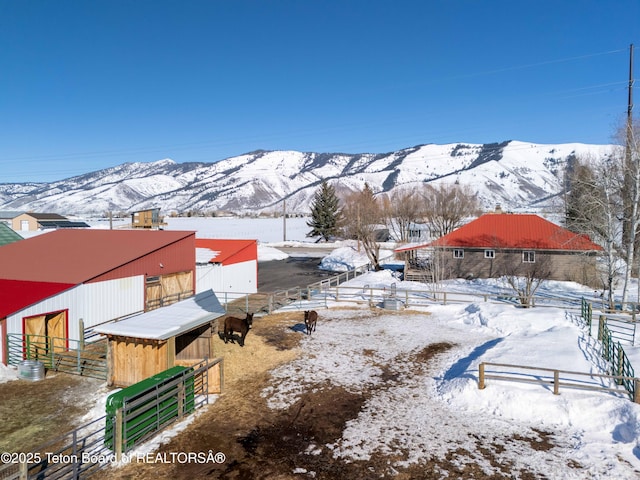 yard covered in snow with an exterior structure, an outdoor structure, and a mountain view