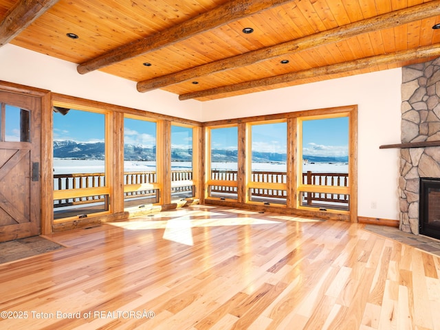 4660 Pale Morning Dr, Tetonia, ID 83452 - unfurnished living room featuring plenty of natural light, wood ceiling, wood finished floors, a fireplace, and a mountain view