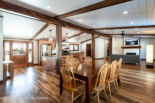 dining room with dark wood finished floors, a fireplace, vaulted ceiling with beams, and recessed lighting