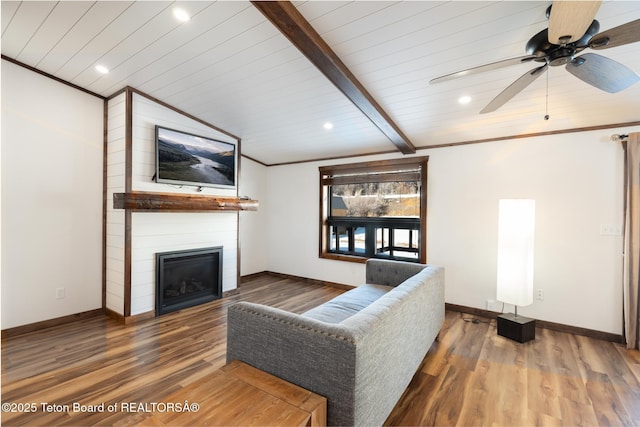 living room with lofted ceiling with beams, ornamental molding, a fireplace, and wood finished floors