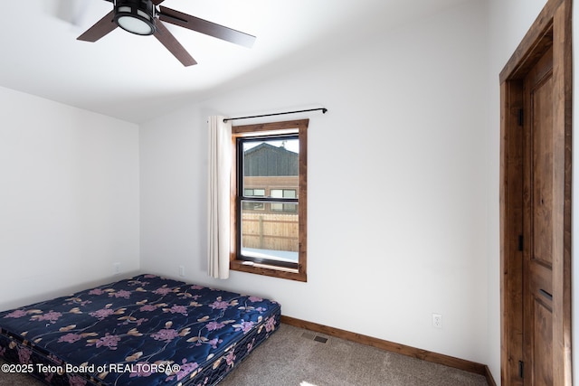 unfurnished bedroom featuring visible vents, baseboards, a ceiling fan, carpet, and vaulted ceiling