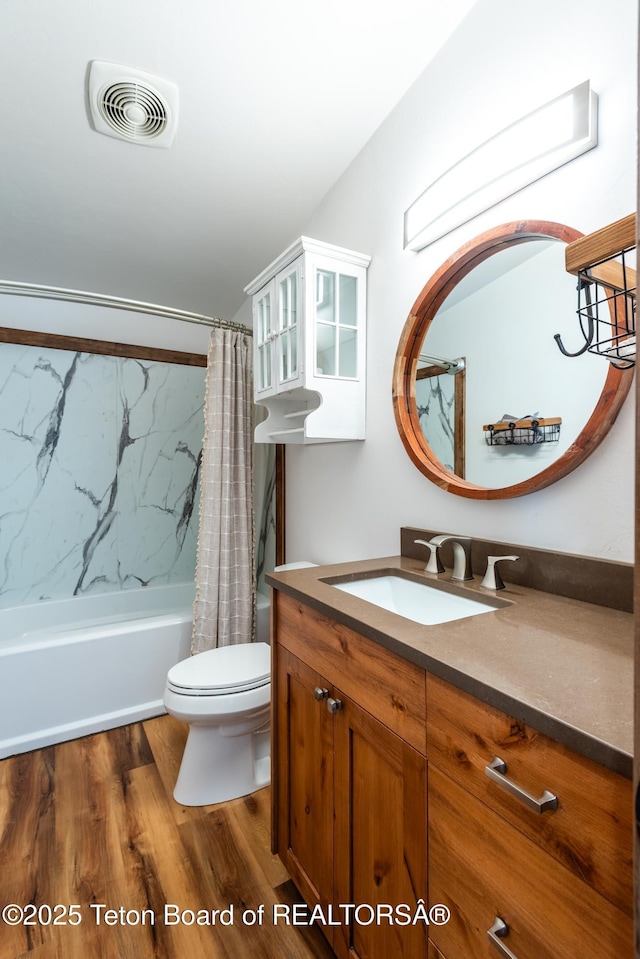 bathroom featuring toilet, shower / tub combo, wood finished floors, vanity, and visible vents