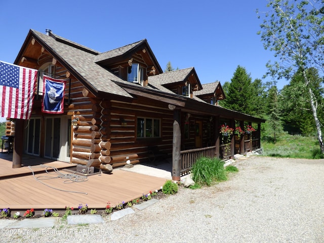 view of home's exterior with roof with shingles and log siding