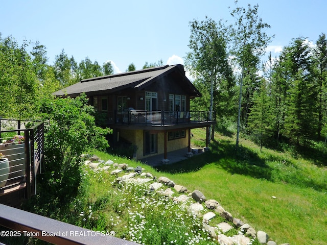 rear view of house with a lawn and a deck