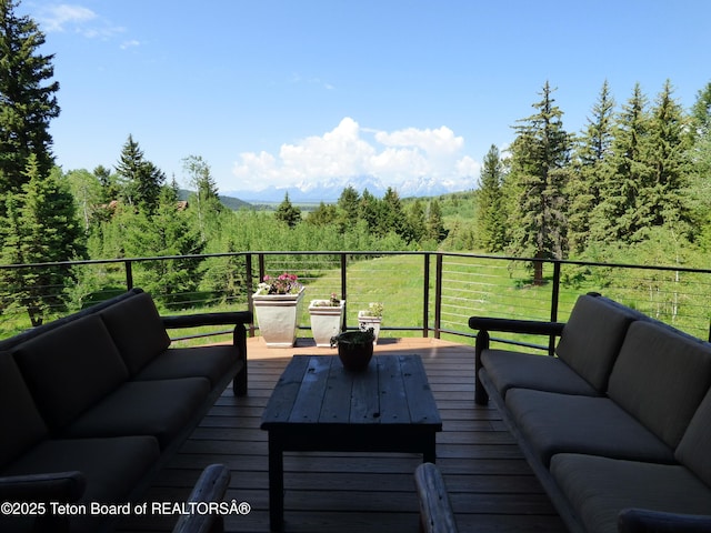 deck featuring an outdoor living space and a view of trees