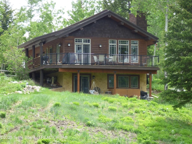 rear view of house with a chimney and a deck