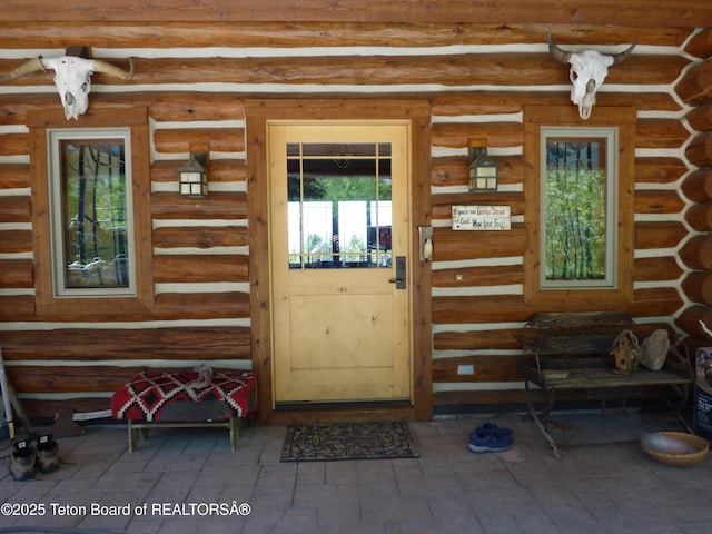 property entrance featuring log exterior