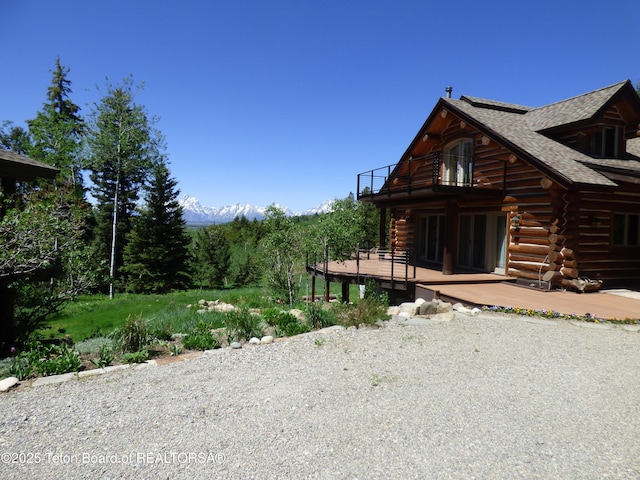 view of front of home featuring a balcony and log siding