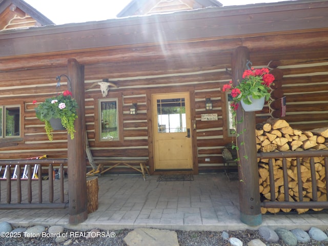 view of exterior entry featuring log siding