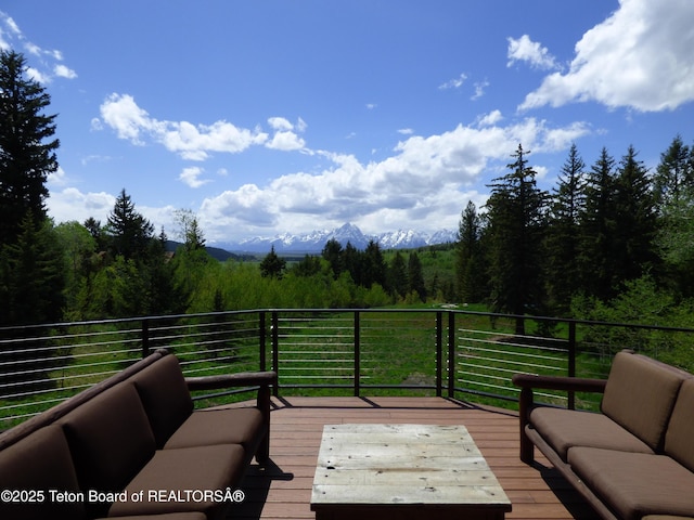 deck with a view of trees and an outdoor hangout area