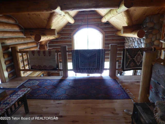 unfurnished living room with vaulted ceiling with beams, wooden ceiling, and hardwood / wood-style flooring