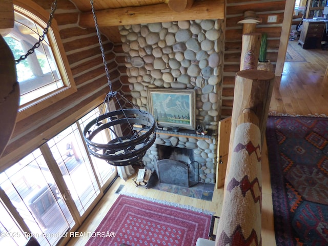 room details featuring visible vents, a fireplace, log walls, and wood finished floors