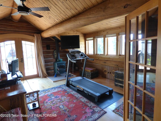 exercise area featuring french doors, vaulted ceiling, log walls, and hardwood / wood-style floors