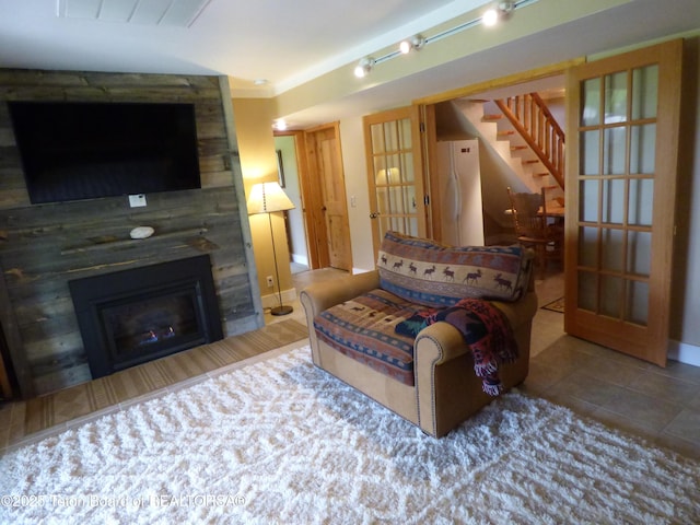 tiled living area with stairs, a fireplace, visible vents, and track lighting