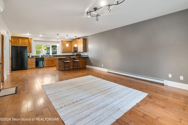 kitchen with light wood-type flooring, brown cabinets, black appliances, and baseboard heating