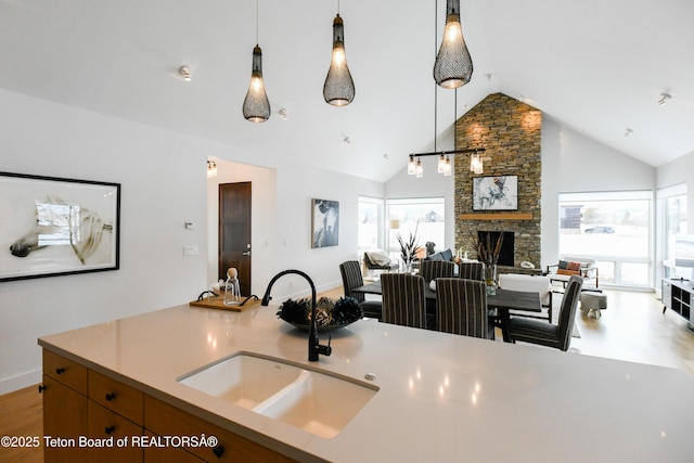 kitchen with a wealth of natural light, open floor plan, pendant lighting, and a sink