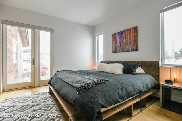 bedroom featuring access to outside and wood finished floors