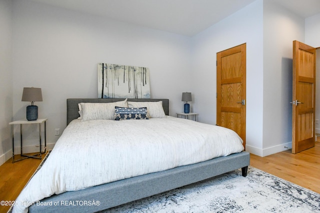 bedroom featuring wood finished floors and baseboards