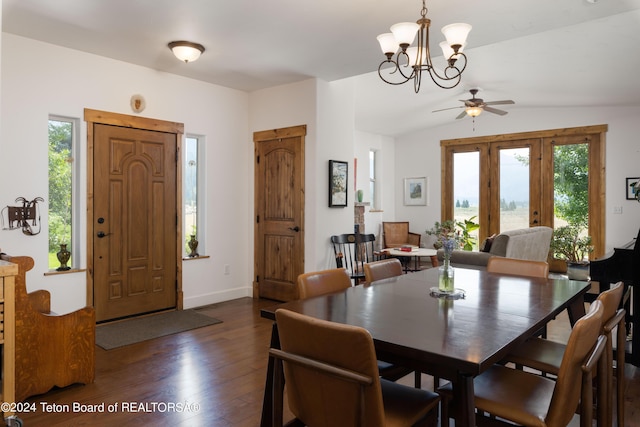 dining area with a chandelier, vaulted ceiling, dark wood finished floors, and baseboards