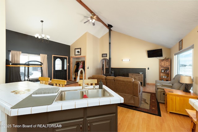 kitchen featuring open floor plan, plenty of natural light, a sink, and tile counters