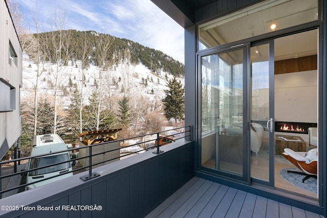 snow covered back of property featuring a mountain view