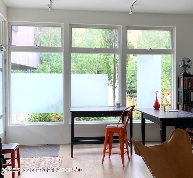 sunroom / solarium featuring track lighting