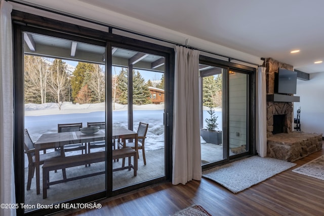 doorway featuring dark wood-style floors, a stone fireplace, and recessed lighting