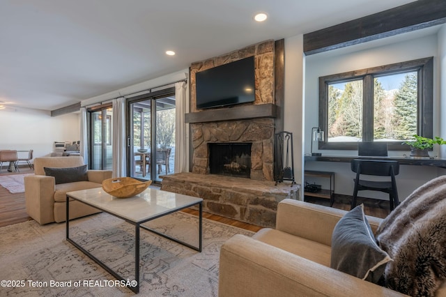 living room featuring recessed lighting, a fireplace, and wood finished floors