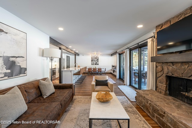 living room featuring a fireplace, wood finished floors, and recessed lighting