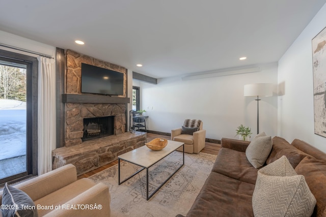 living area featuring light wood-style floors, recessed lighting, a fireplace, and baseboards