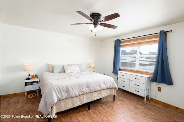 bedroom featuring a ceiling fan, baseboards, and wood finished floors