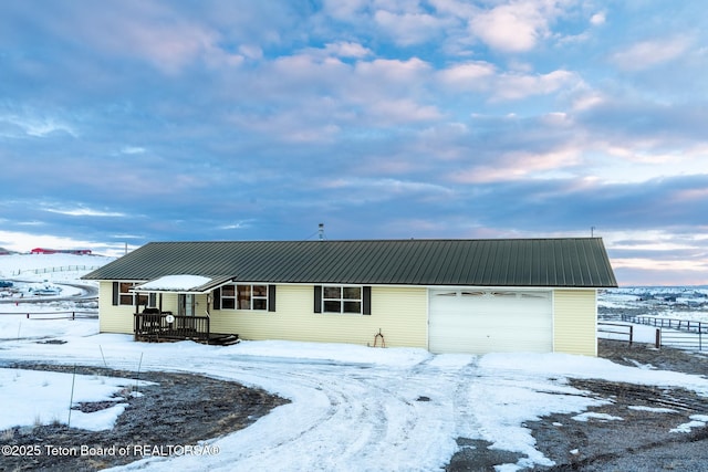 view of front of home with metal roof and fence