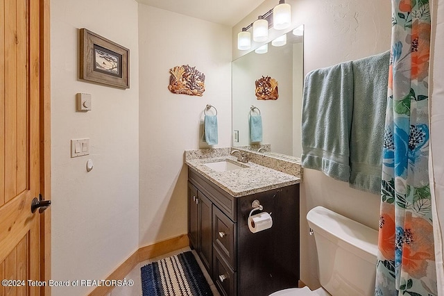 bathroom featuring vanity, toilet, and baseboards