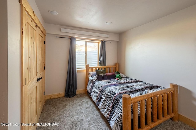 bedroom with baseboards and light carpet