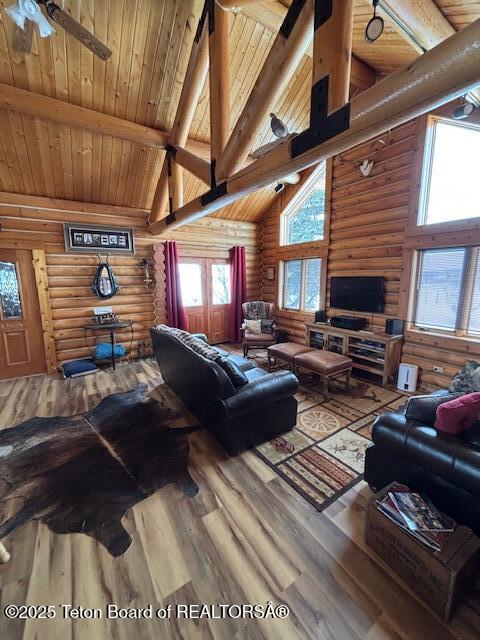 living area with high vaulted ceiling, beamed ceiling, wooden ceiling, and wood finished floors