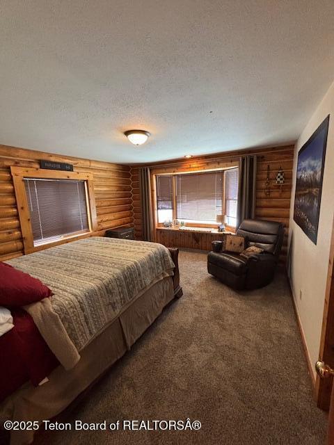 bedroom featuring carpet floors, log walls, a textured ceiling, and baseboards