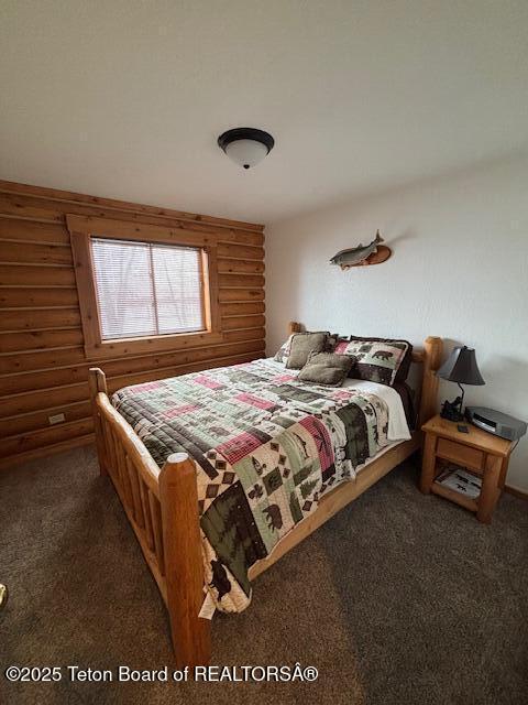 carpeted bedroom featuring rustic walls