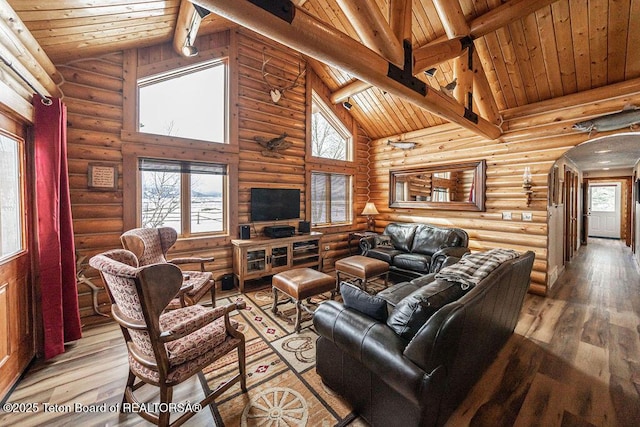 living area featuring wood finished floors, high vaulted ceiling, arched walkways, wooden ceiling, and beamed ceiling