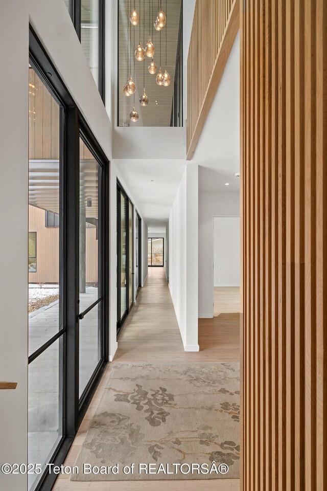 hall with a towering ceiling and wood finished floors